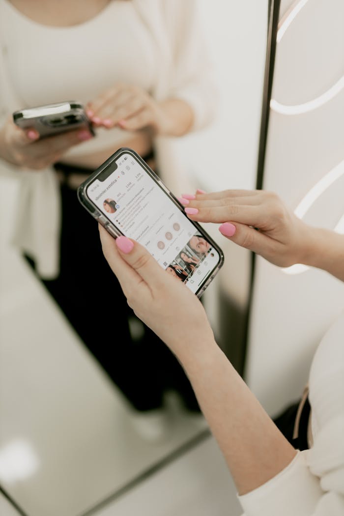 services-05 Close-up of a woman using her smartphone in front of a mirror indoors.